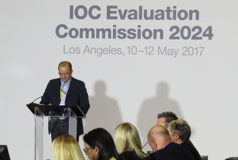 IOC 2024 Evaluation Commission Chair Patrick Baumann makes remarks at opening meeting with Commission members in foreground (GamesBids photo)
